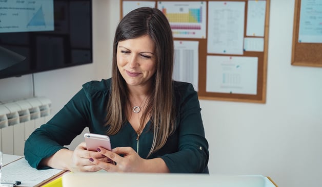 female-school-teacher-using-cellphone-at-her-desk