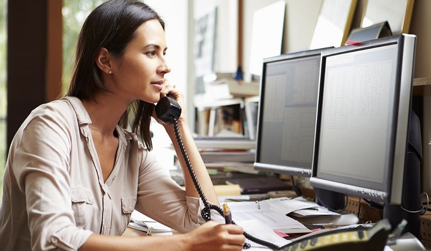 woman-talking-on-phone-and-using-computer