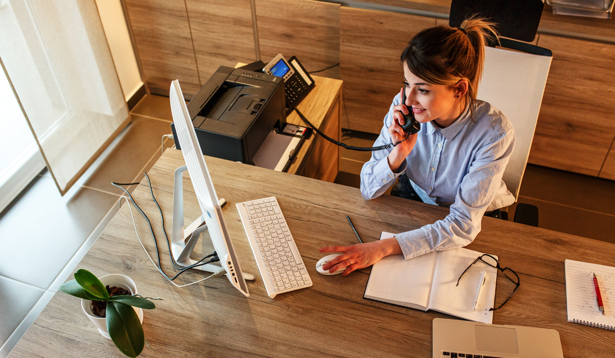 Woman using phone in nice office with desktop