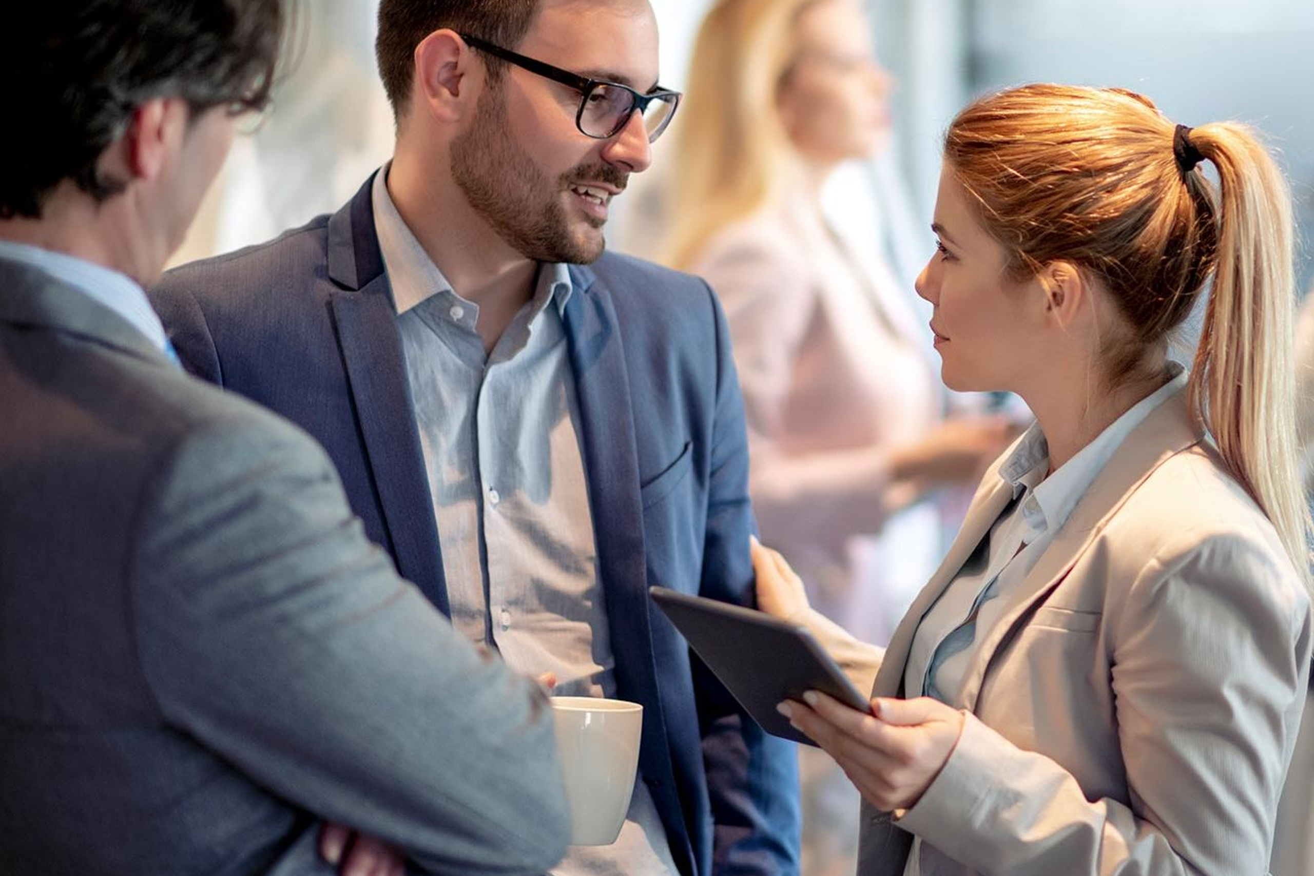 Woman with tablet talking to man about business