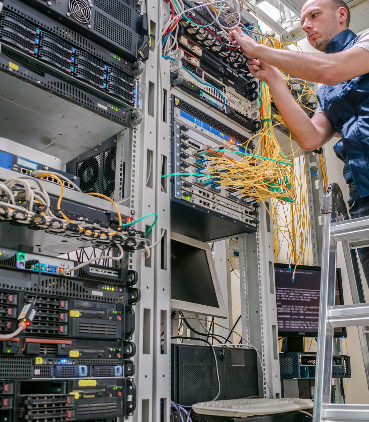 technician wiring cables onto server rack