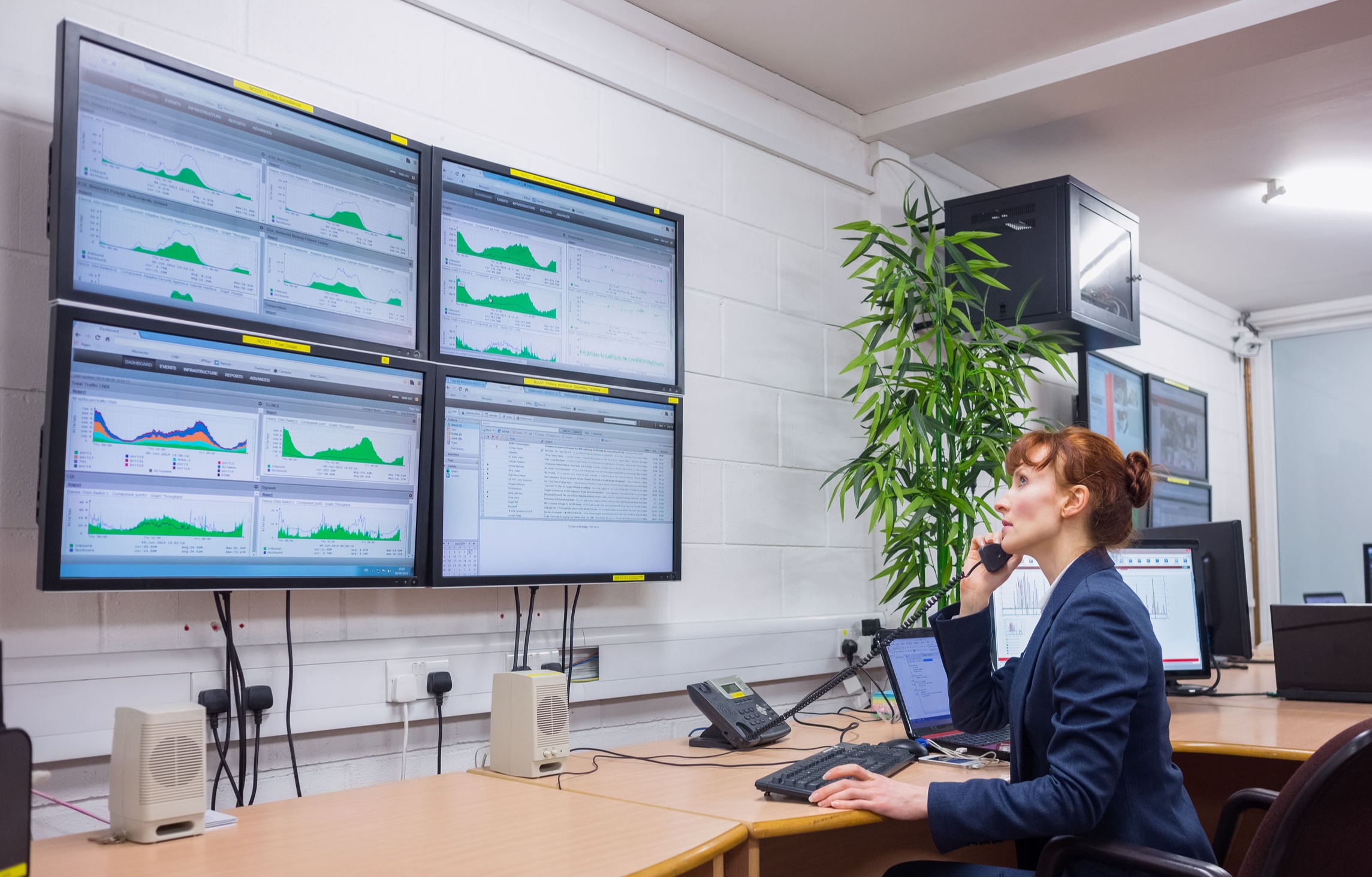 woman looking at analytics dashboard on screens while talking on phone