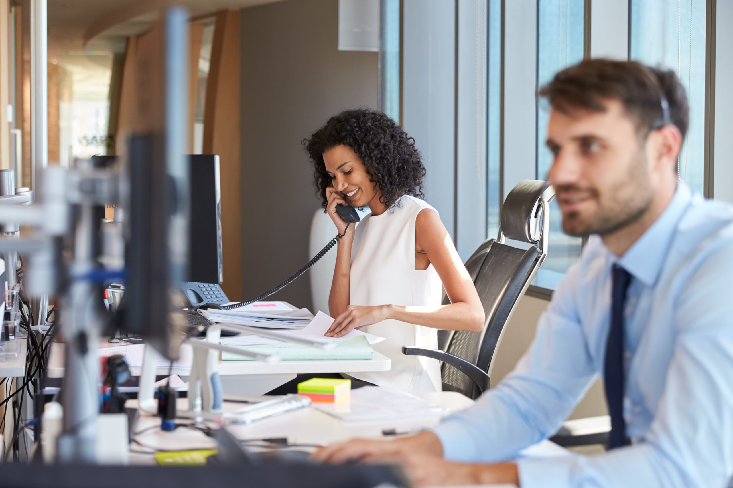 man and woman working in busy office