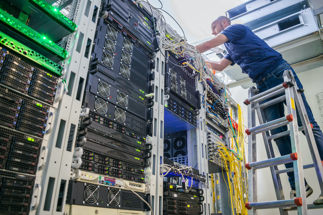 man on ladder installing network cables