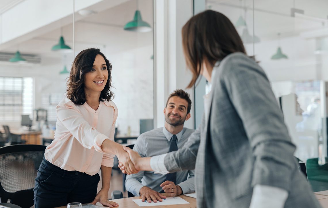 two women shaking hands