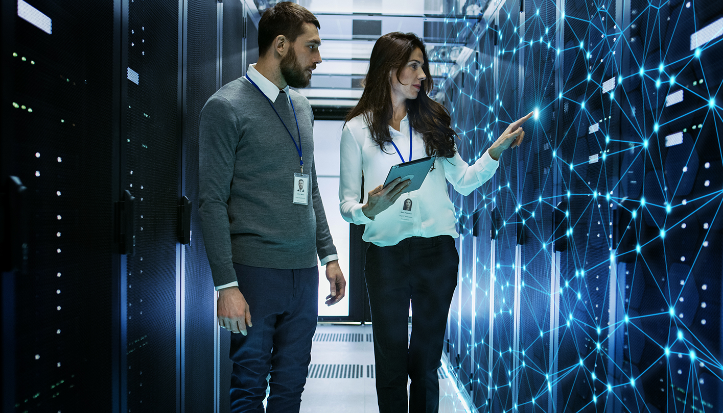 man and woman looking at server room