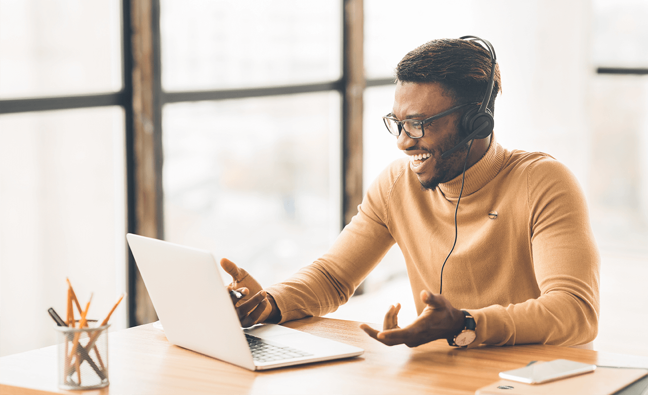 man talking on phone while on laptop