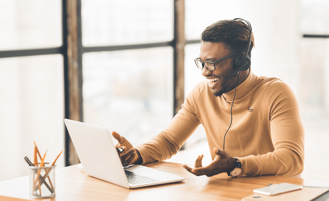 man talking on headset in front of laptop