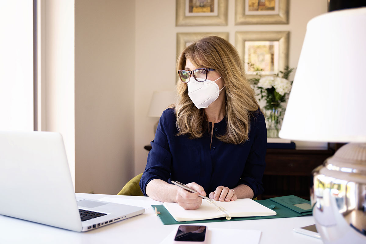 woman wearing mask while working at home