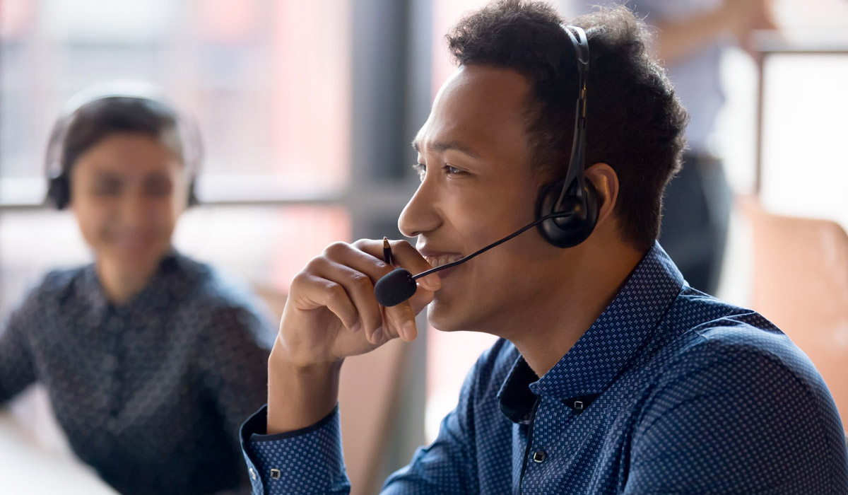 Smiling young businessman call center agent at workplace