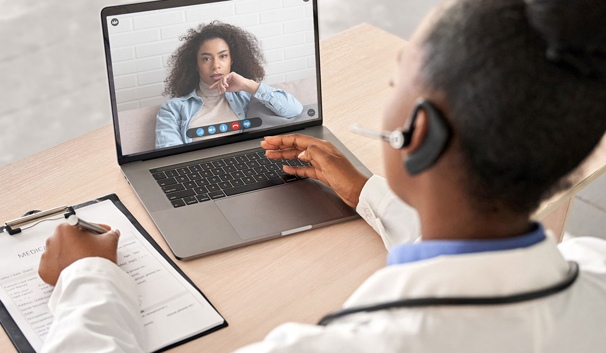 black female doctor chatting with patient over video conference