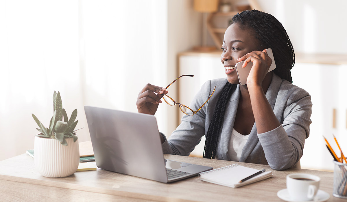 woman chatting on her phone sitting at a desk